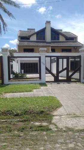 a house with a gate in front of a building at Sobrado em Imbé - RS in Imbé