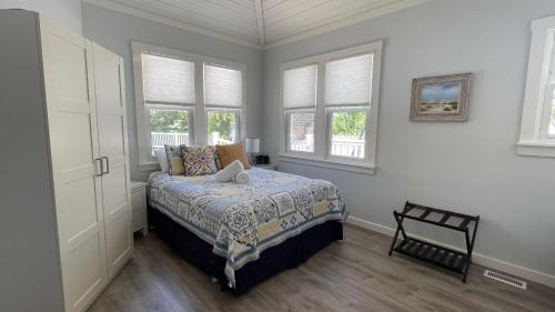 a bedroom with a bed and two windows at Sandy Shores in Union Pier