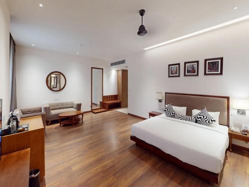 Un dormitorio con una cama y una sala de estar. en Sunday Resort & Spa by CheckIn Manesar Gurugram, en Gurgaon