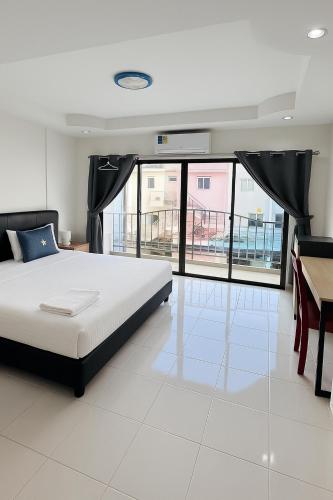 a bedroom with a bed and a table and windows at Smile room 21 in Patong Beach
