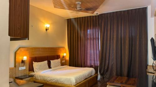 新德里The Royal Metropolitan IGI Airport Delhi的一间带床的卧室和一扇带窗帘的窗户