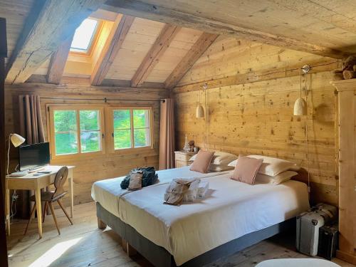 um quarto com uma cama grande num quarto de madeira em Alpen Charme - Chalet d'Hôtes et SPA em Gsteig