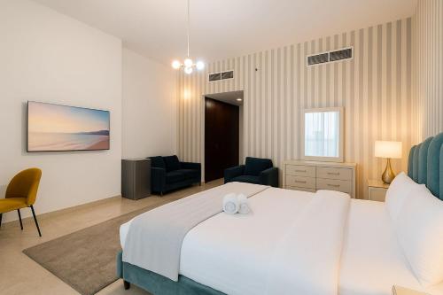 een slaapkamer met een groot wit bed en twee stoelen bij Cloud 9 Room Marina in Dubai