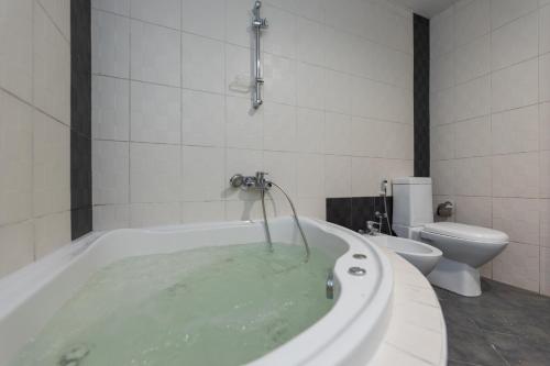 een badkamer met een bad gevuld met water en een toilet bij Cloud 9 Room Marina in Dubai