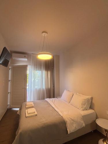 Storks apartments في كورينوس: غرفة نوم مع سرير كبير مع ضوء