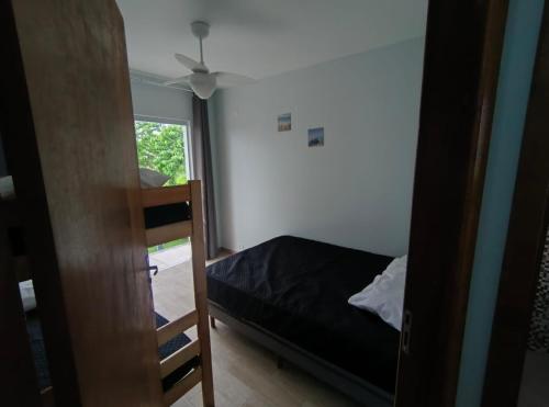 een kleine slaapkamer met een bed en een raam bij Sobrado 3 Condomínio Sobre as Ondas, 4min a pe da Praia in Guaratuba