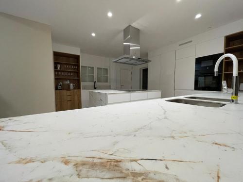 een witte keuken met een groot marmeren aanrecht bij Luxury Home Estefania in Chayofa