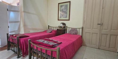2 letti con lenzuola rosa in una camera di Gualeguay Centro a Gualeguay