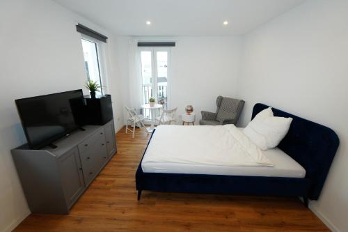 ein Schlafzimmer mit Bett und Flachbildfernseher in der Unterkunft Livery in Koblenz