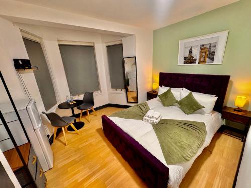 a bedroom with a bed and a table and chairs at Stylish Room in Central London! in London