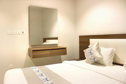 a bedroom with a bed with a large mirror at النسمة الهادئة in Jeddah