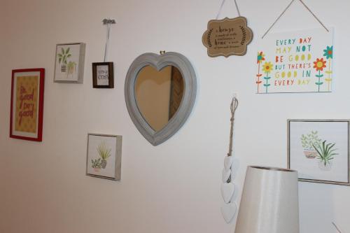 eine Wand mit Bildern und einem Spiegel an der Wand in der Unterkunft Oliver Wests Beautiful 2 Bedroom Sleeps 4 Apartment in Scarborough