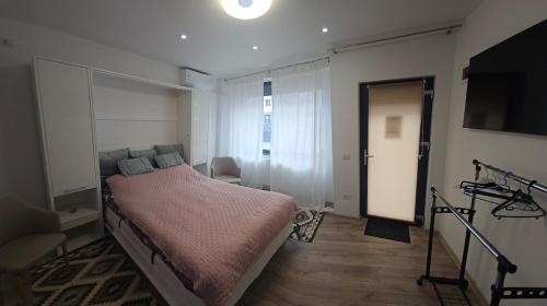 een slaapkamer met een bed en een televisie. bij East apartment in Tecuci