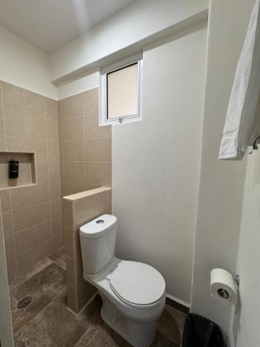 Aeropuerto Express Huatulco في Bahías de Huatulco: حمام مع مرحاض أبيض ونافذة