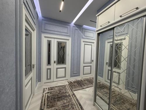 pasillo con puertas blancas y suelo de baldosa en Tashkent City Apartments E2, en Tashkent