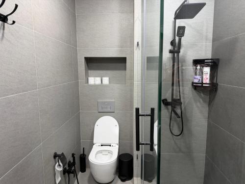 Un pequeño baño con inodoro y ducha. en Tashkent City Apartments E2, en Tashkent