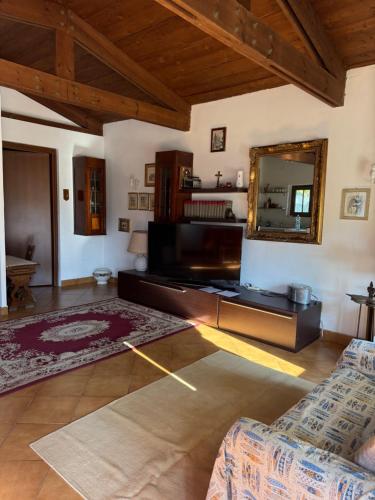 sala de estar con espejo y sofá en Green Cottage, en Casal Palocco