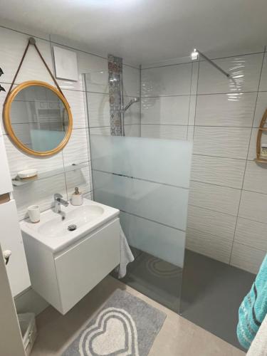 a bathroom with a sink and a glass shower at À la clef des champs in Chauray