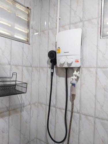 a bathroom with a white shower with a hose at Little Shark bungalow in Ban Bang Bao