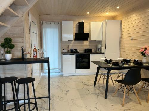 een keuken met witte kasten en een tafel en stoelen bij Sunny Baltic in Jarosławiec