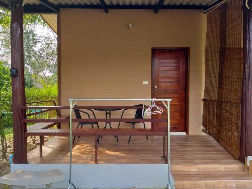 eine Veranda eines Hauses mit einem Tisch und Stühlen in der Unterkunft Little Shark bungalow in Ban Bang Bao