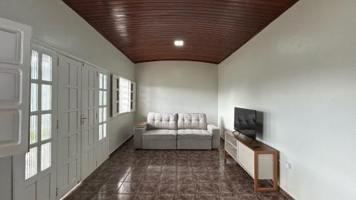 Residencial Paraviana-Casa Piscina في بوا فيستا: غرفة معيشة مع أريكة وتلفزيون