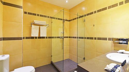 Un baño con ducha, inodoro y lavabo. en Hotel 33 Kampala, en Kampala
