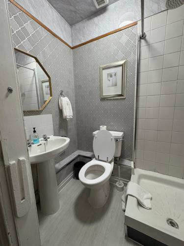 a bathroom with a toilet and a sink at Piccolo Guest House in Glasgow