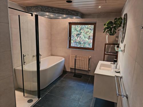 a bathroom with a tub and a sink at Krumm und Schief Appartments in Brunau