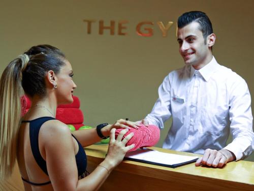 a woman is putting a sock on a persons hand at Lancaster Tamar Hotel- Hadath in Beirut