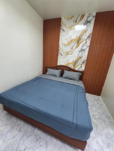 un letto in una camera da letto con un dipinto sul muro di Country House a Ban Nong Chaeng