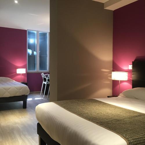 Cette chambre d'hôtel dispose de 2 lits et de murs rouges. dans l'établissement Le Brin D'olivier, à Bourg-Saint-Andéol