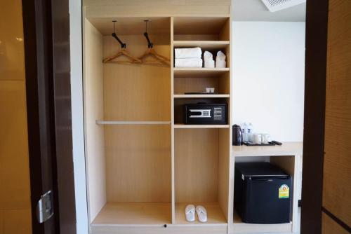 a closet with a cupboard with a appliance in it at Beston Pattaya - SHA Plus Certified in Pattaya South