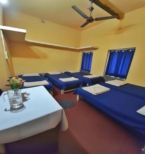 a room with blue tables and chairs and windows at The OLD house in Bolpur