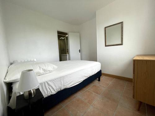 ein Schlafzimmer mit einem weißen Bett und einem Spiegel in der Unterkunft Charmant logement avec parking privé - proche village et plage - Veules-les-Roses in Veules-les-Roses