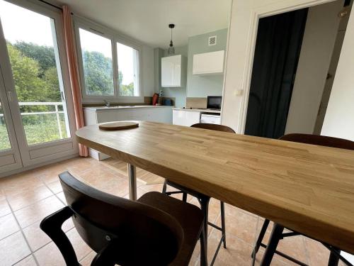 eine Küche mit einem Holztisch und Stühlen in der Unterkunft Charmant logement avec parking privé - proche village et plage - Veules-les-Roses in Veules-les-Roses