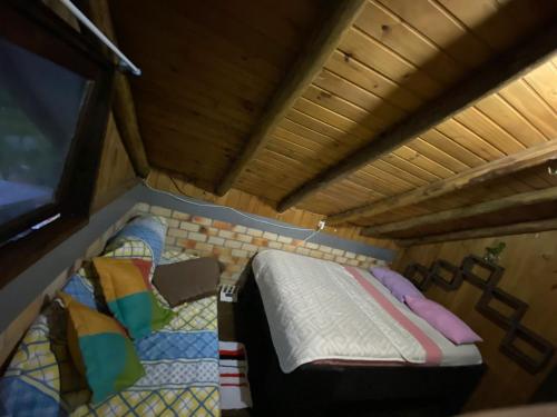 a small bed in the middle of a room at Hostel Paraíso Embaú in Guarda do Embaú