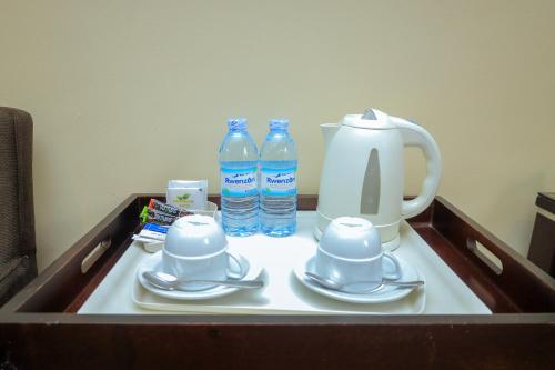 Una bandeja con una tetera y dos botellas de agua. en Hotel 33 Kampala, en Kampala