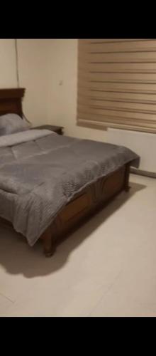 1 cama con marco de madera en un dormitorio en شقه مفروشه بالكامل في عمان شارع مكه ضاحيه الأمير راشد, en Amán