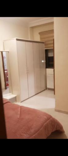 1 dormitorio con armarios blancos y 1 cama. en شقه مفروشه بالكامل في عمان شارع مكه ضاحيه الأمير راشد, en Amán