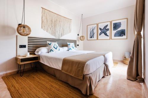 a bedroom with a large bed with blue pillows at Apartamentos Ses Veles in Cala Llonga