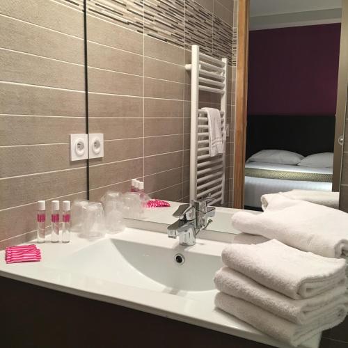 une salle de bain avec un lavabo et un miroir dans l'établissement Le Brin D'olivier, à Bourg-Saint-Andéol