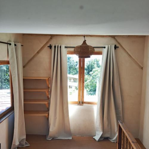 a window in a room with a curtain and stairs at Casa Zapote in Sololá