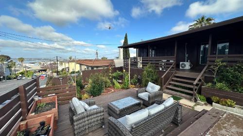 a balcony with chairs and an airplane flying over a house at Suite Steps to San Diego Top Spots in San Diego