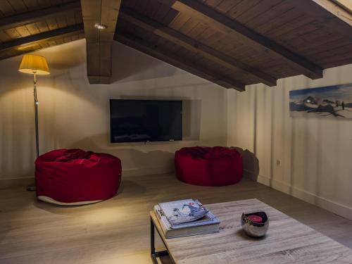 a living room with two red bean bags and a tv at Central & Elegant Apartments,partially with Fireplace, by Zermatt Rental in Zermatt