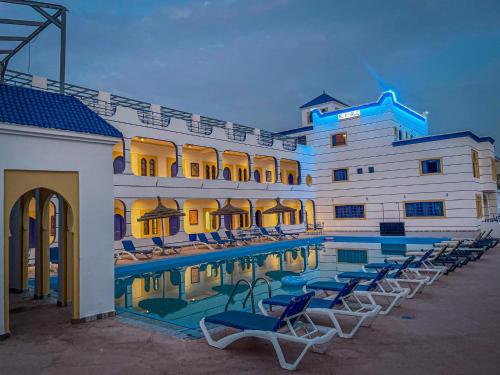 a hotel with a swimming pool and lounge chairs at arganier solitaire in Souira Guedima