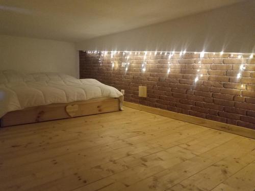 a room with a bed and a brick wall at Nid cozy au Lioran in Le Lioran