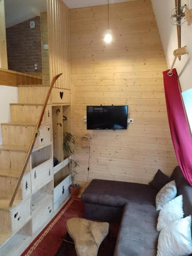 a living room with a couch and a flat screen tv at Nid cozy au Lioran in Le Lioran