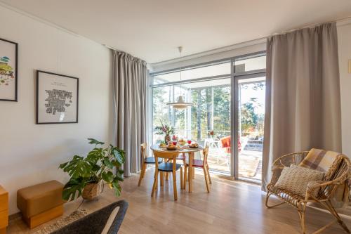 a living room with a table and chairs and a window at RUF studio Naantali- Unique design apartment in Naantali