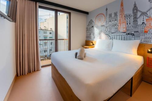 a bedroom with a large white bed and a window at easyHotel Valencia Ciutat Vella in Valencia